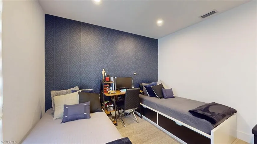 Bedroom with recessed lighting, visible vents, and an accent wall