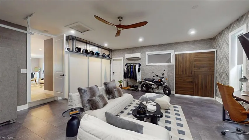 Bedroom with baseboards, a ceiling fan, and an AC wall unit