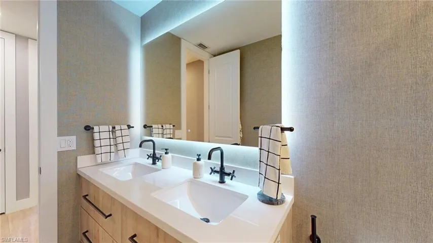 Full bath featuring a sink, double vanity, and visible vents