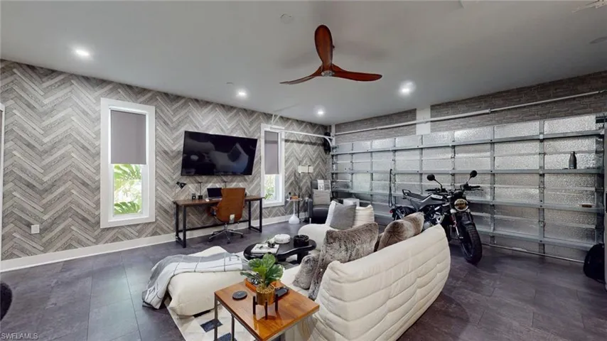Living area with a ceiling fan, baseboards, a garage, and recessed lighting