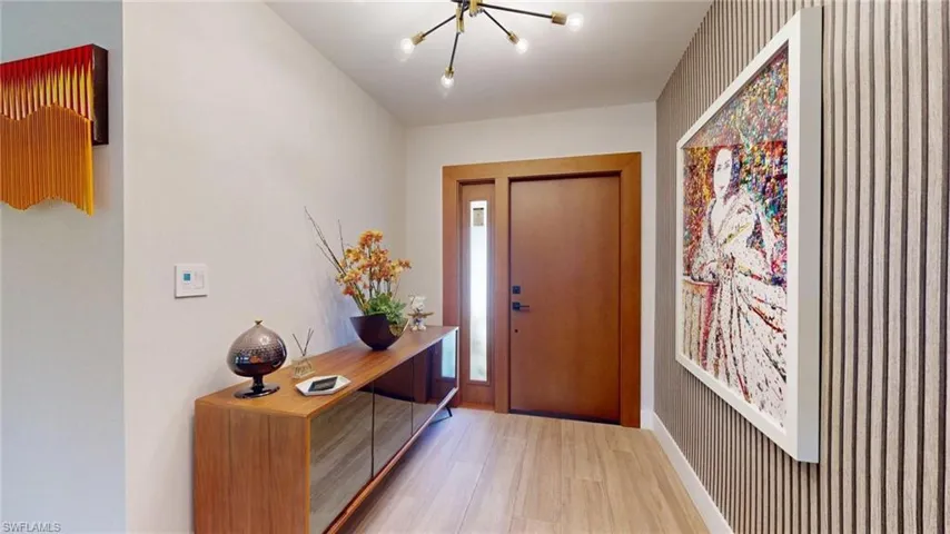 Entryway featuring an inviting chandelier, baseboards, and wood finished floors