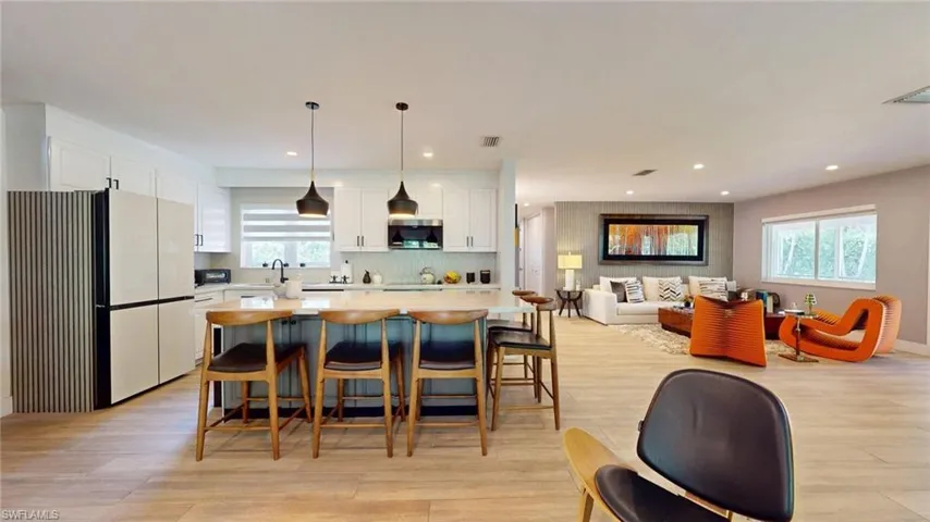 Kitchen featuring freestanding refrigerator, white cabinets, and light wood-style floors