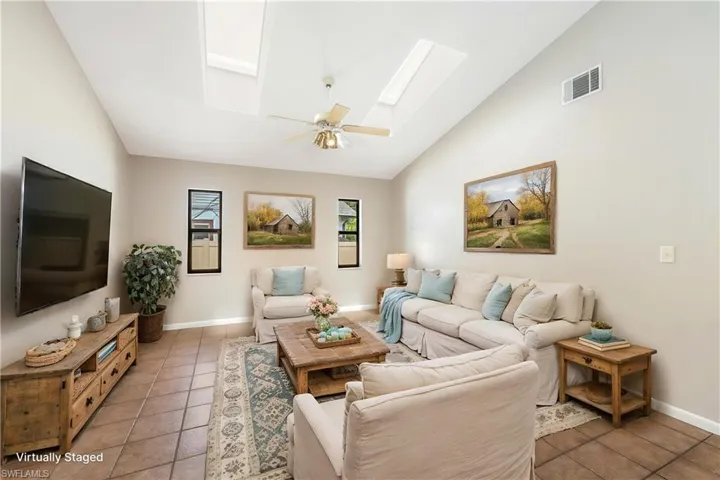 Virtually Staged -Vaulted ceiling featuring skylights and a ceiling fan