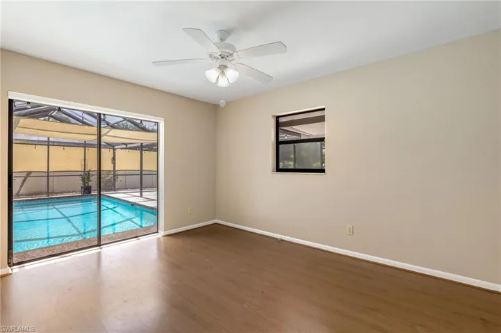 Room with wood-finish flooring and a white ceiling fan