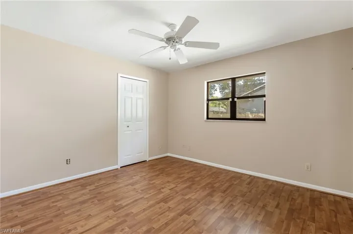 Room featuring wood-finish flooring, neutral wall tones, and white trim