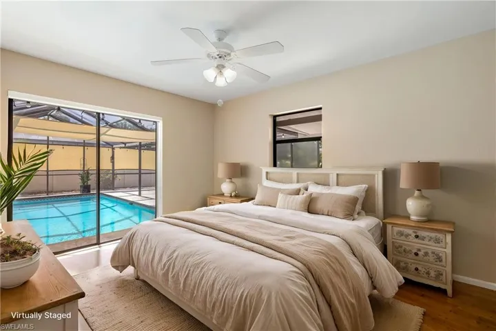 Virtually Staged - Bedroom featuring wood-finish flooring, a ceiling fan with integrated lighting, and direct access to an enclosed pool area