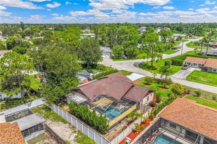 Single-story residence featuring a brown shingle roof and a screened-in pool enclosure