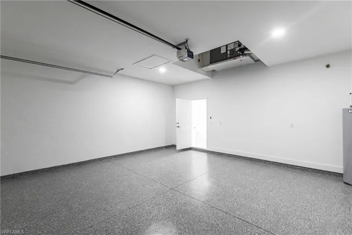 Garage featuring a garage door opener and water heater