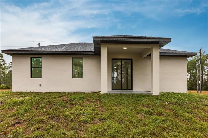 Rear view of property with a lawn
