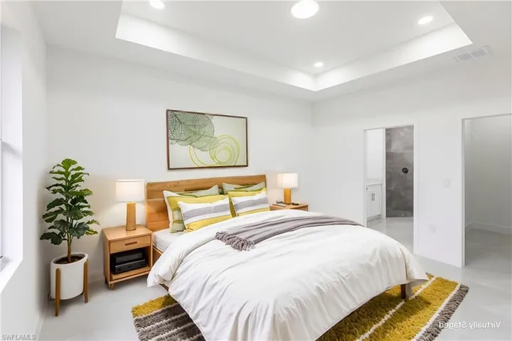 Bedroom featuring a tray ceiling and connected bathroom