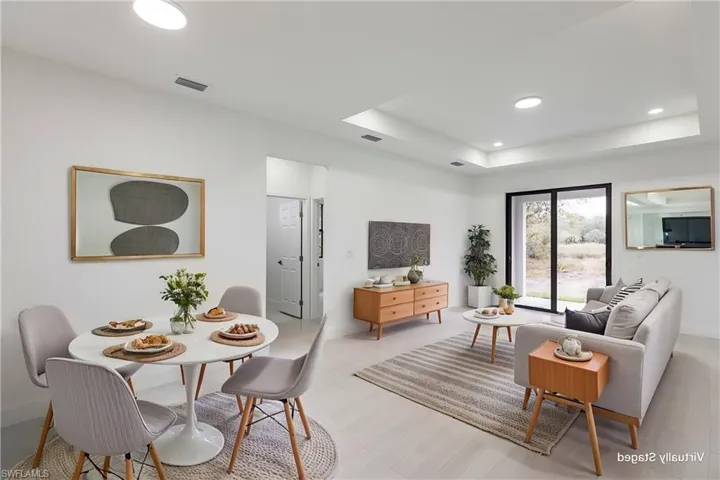Living room with a raised ceiling and light wood-type flooring