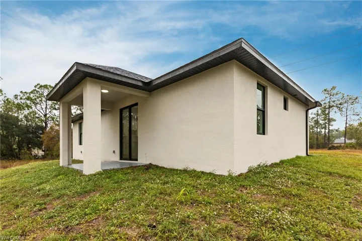 Rear view of property featuring a yard and a patio area