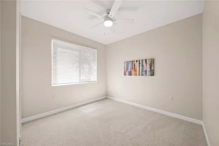 Spare room with a ceiling fan and light carpet