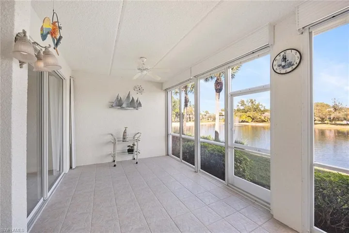 Unfurnished sunroom with ceiling fan and a water view