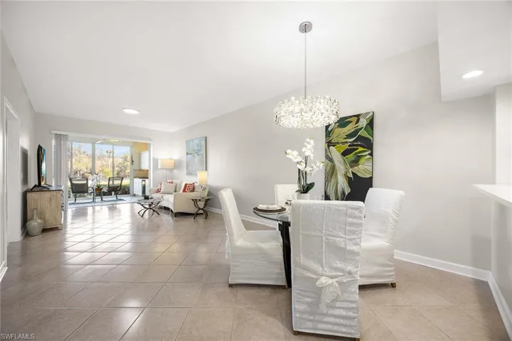 Dining space with light tile patterned floors and hanging lights