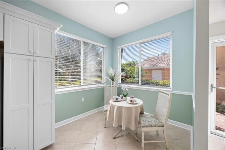 Dining space with light tile patterned flooring and baseboards