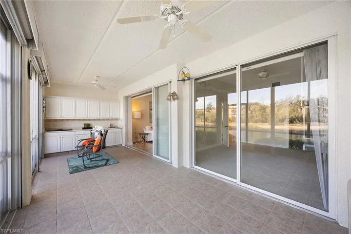 Sunroom featuring a ceiling fan and a water view