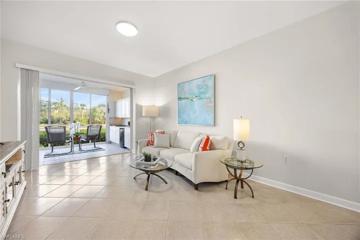 Living room featuring light tile patterned flooring and ceiling fan