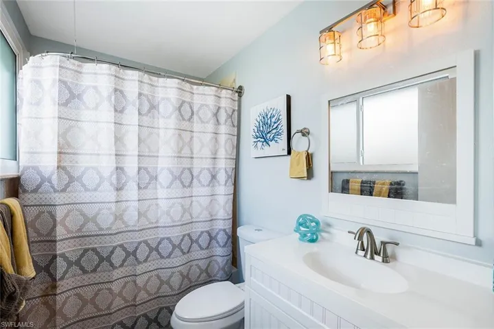 Full bathroom with vanity and curtained shower