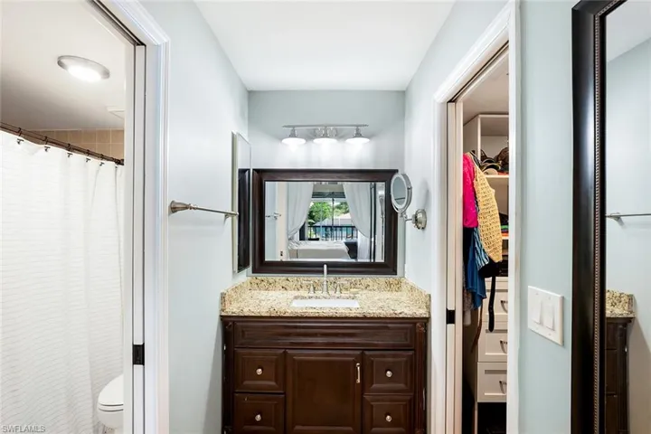 Full bath featuring vanity, a shower with shower curtain, and a walk in closet