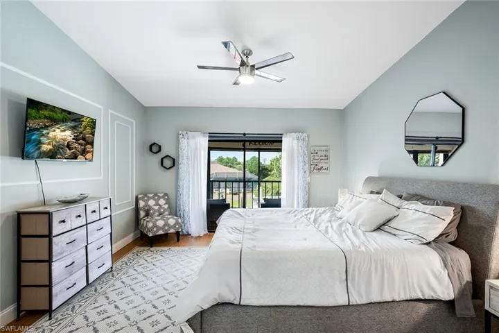 Bedroom with access to outside, light wood-style floors, a ceiling fan, and lofted ceiling