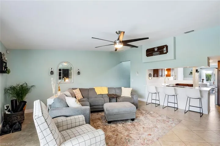 Living area featuring a ceiling fan and light tile patterned floors
