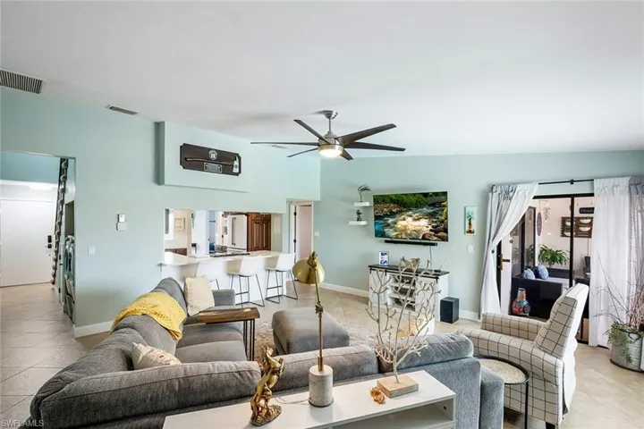 Living area featuring light tile patterned floors and a ceiling fan