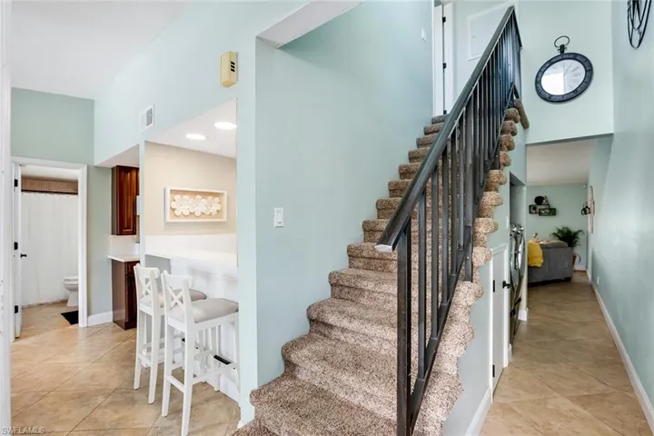 Stairway with tile patterned flooring and baseboards
