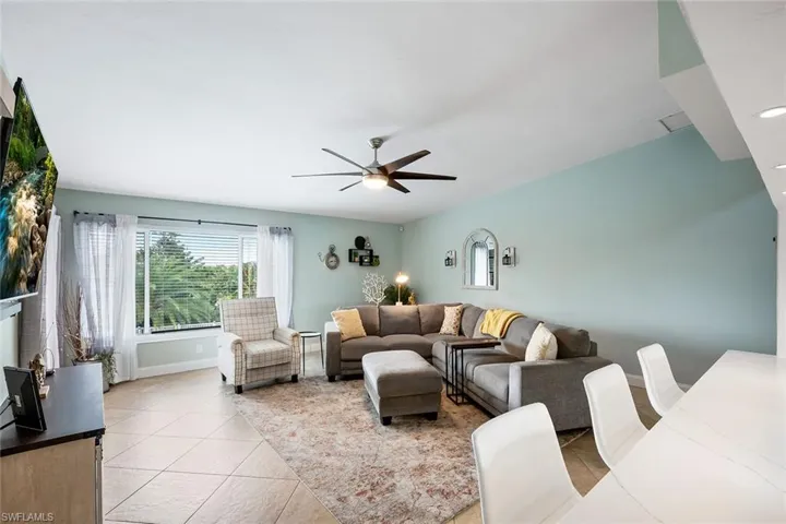 Living room with a ceiling fan and light tile patterned floors