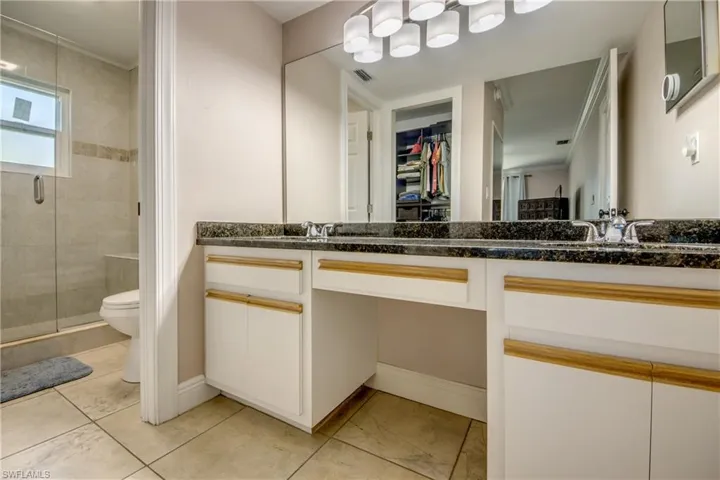 Dual sink vanity, makeup area and a large walk-in closet