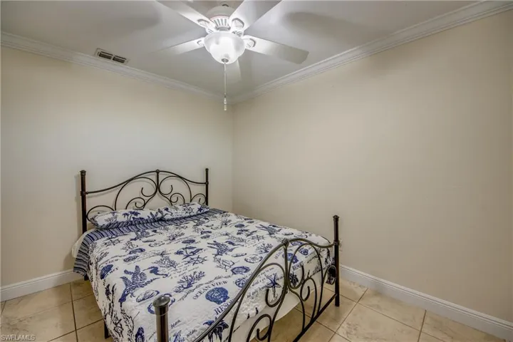 Secondary bedroom with crown molding and ceiling fan