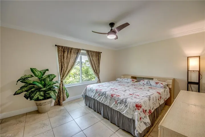 Extra-large bedroom with ceiling fan and crown molding