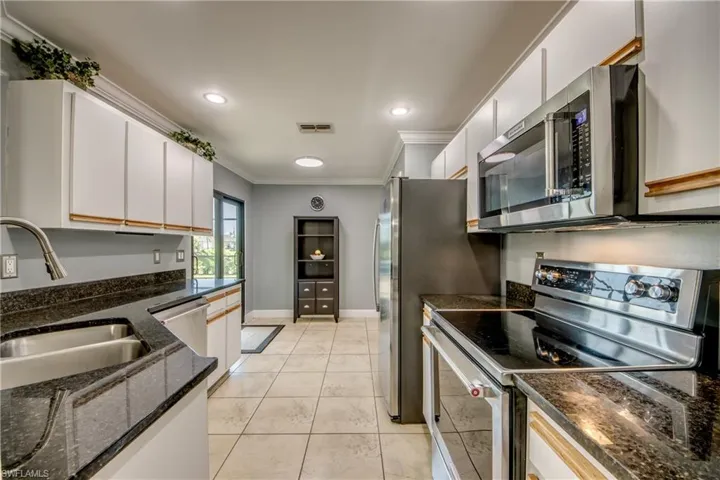 Kitchen featuring SS appliances, crown molding and white cabinetry