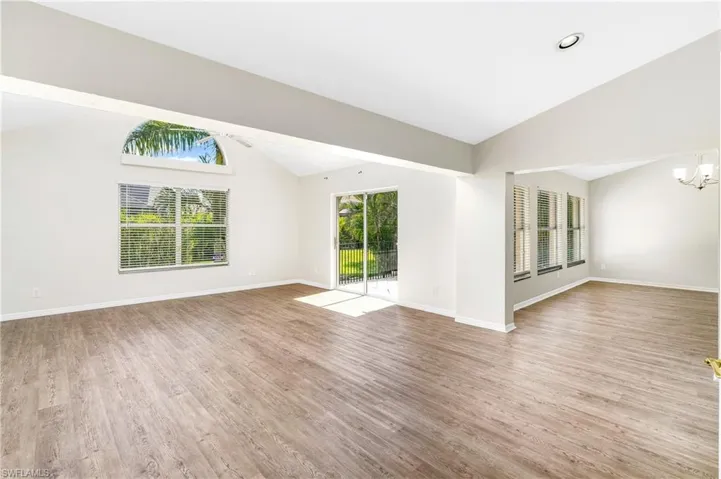Spacious living room with soaring vaulted ceilings and abundant natural light,
