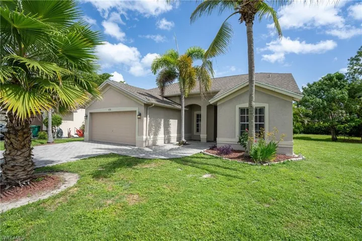 Single-story residence featuring a stucco exterior with a hip roof, a paver driveway, and an attached two-car garage