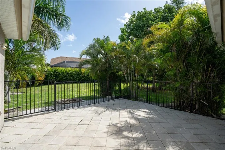 Private paved patio with tropical landscaping.