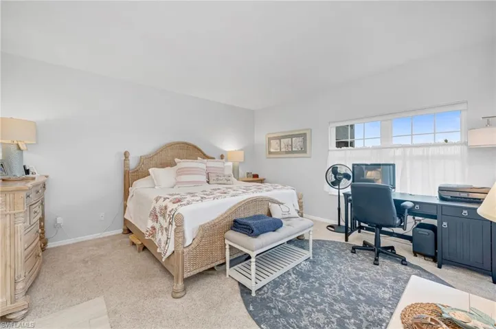 The serene primary suite offers direct lanai access, plush carpeting, and an updated en-suite bath.