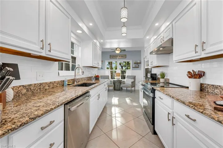 The bright and modern kitchen boasts granite countertops, stainless steel appliances, and ample storage.