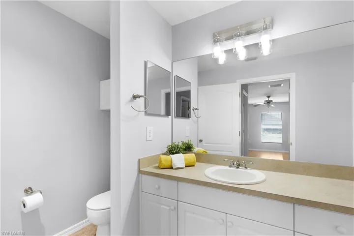 Vanity with an integrated sink, brushed nickel faucet, and a large mirror