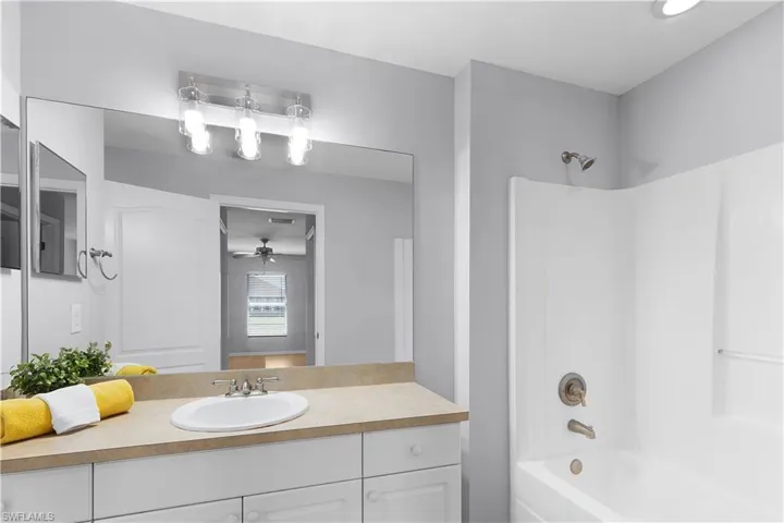 Single vanity with a white basin and light-toned countertop