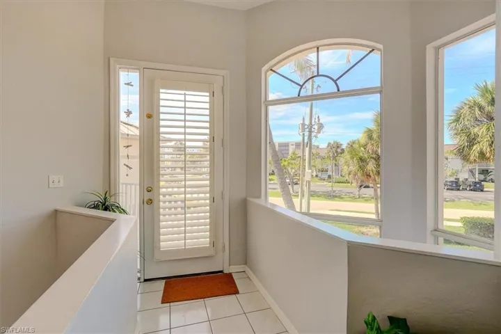 Doorway to outside with light tile patterned flooring and baseboards