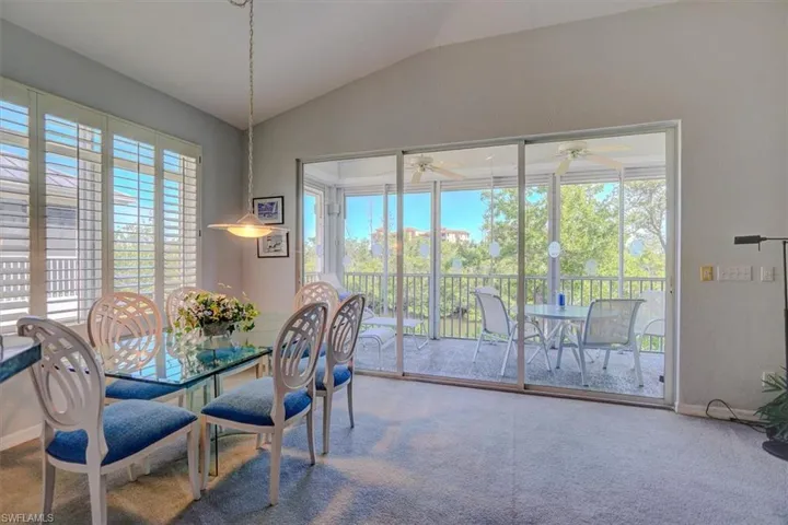 Dining space featuring lofted ceiling, carpet, and ceiling fan