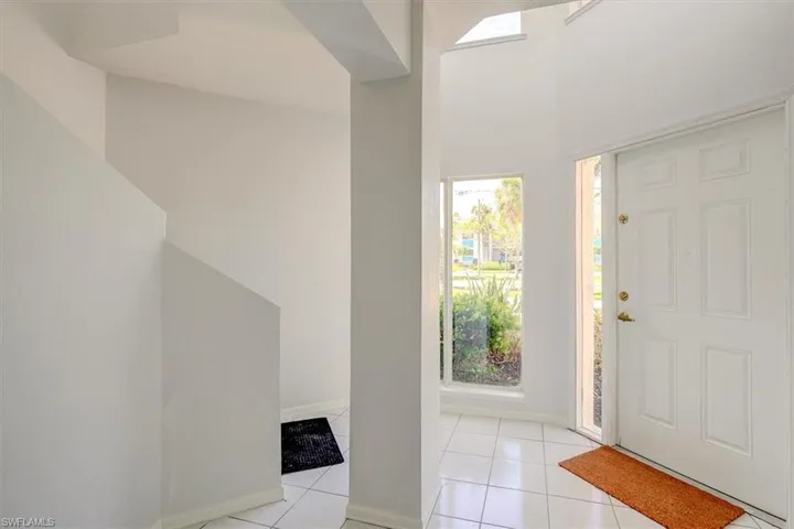 Entryway with light tile patterned flooring and baseboards