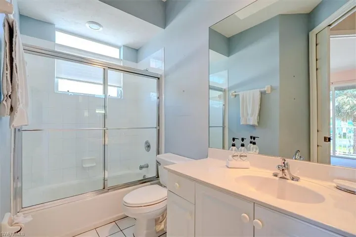 Bathroom with vanity, enclosed tub / shower combo, and tile patterned floors