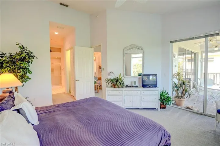 Bedroom with access to exterior, light colored carpet, and multiple windows