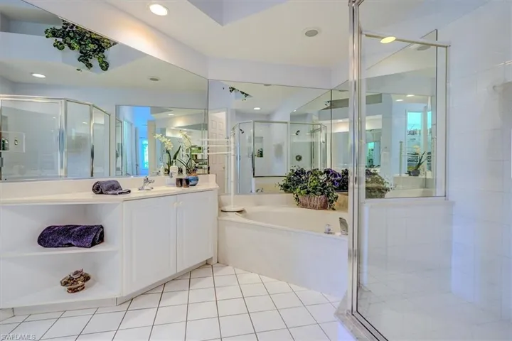Bathroom with a shower stall, vanity, a garden tub, and tile patterned flooring