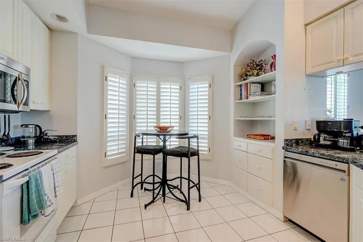 Kitchen with appliances with stainless steel finishes, white cabinets, and open shelves