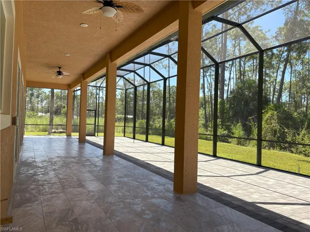 Unfurnished sunroom featuring a ceiling fan and a patio area