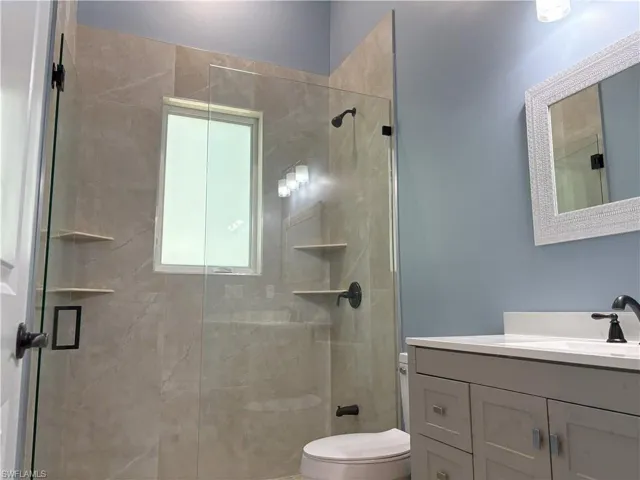 Full bathroom featuring vanity and a shower stall