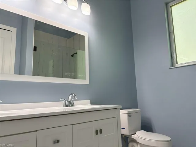 Full bathroom with a marble finish shower and double vanity